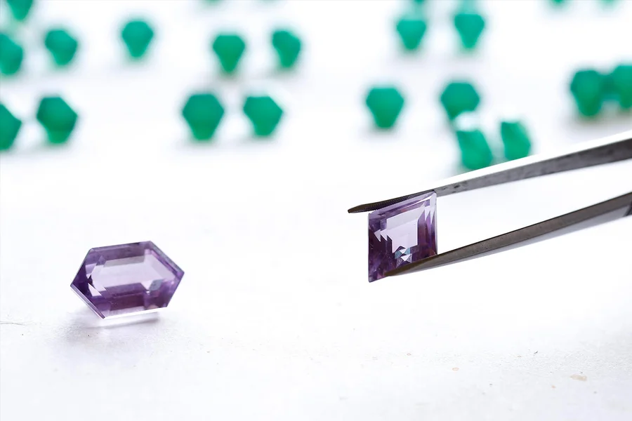 Gemstones being sorted with tweezers at the grading desk